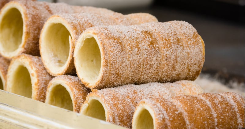 découvrez le trdelník à prague, une délicieuse pâtisserie enroulée, cuite à la perfection et saupoudrée de sucre. explorez les saveurs sucrées et les garnitures qui font de ce dessert un incontournable de la cuisine tchèque.